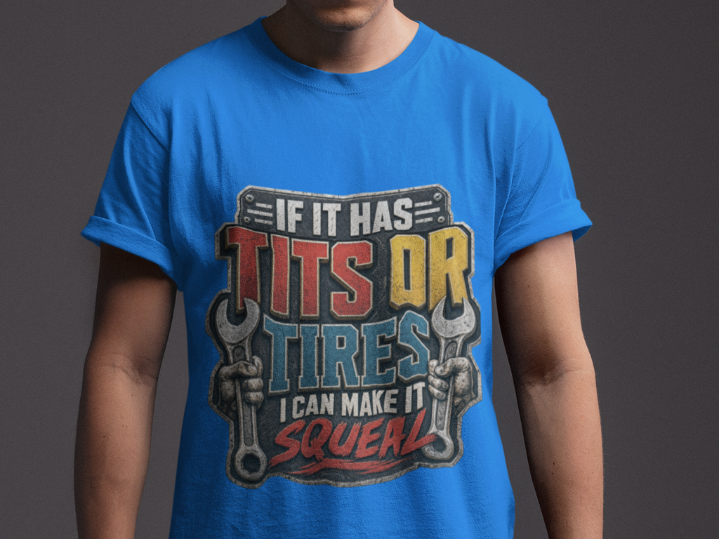 A man wearing a bright blue graphic t-shirt with a humorous slogan about tires and wrenches, posed against a dark gray studio background.